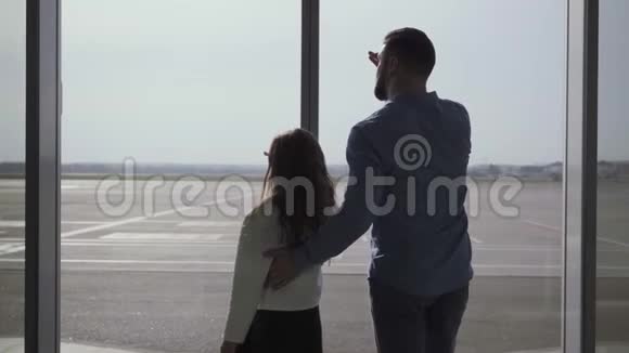 在跑道上的玻璃机场门外白种人男子和小女孩的背影父亲和视频的预览图