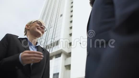 女商人与男伴握手成功晋升面试视频的预览图