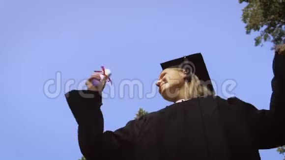 女毕业生在空中挥舞毕业帽视频的预览图