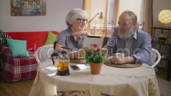 可爱的老年退休家庭夫妇观看家庭照片视频的预览图