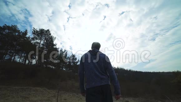 男人走回森林的背影草坪和拳击慢慢地视频的预览图