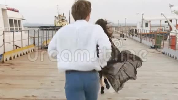 男人追女人跑的背影码头上的拥抱情侣视频的预览图