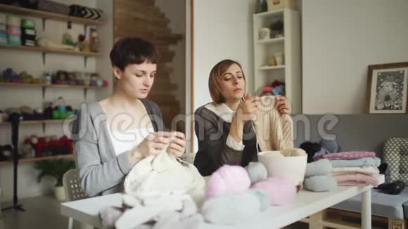 在纺织车间两个女人正坐在桌子上做羊毛织物视频的预览图
