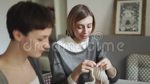 两个年轻女子在纺织车间一起编织羊毛纱编织组视频的预览图