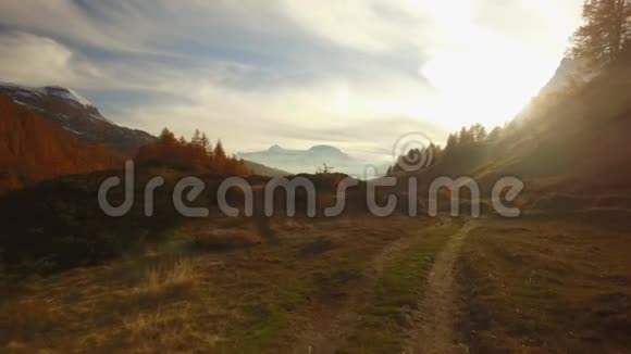 在日落时POV在秋天的小路上步行到树林山谷和雪地上太阳耀斑阳光明媚的秋日五彩缤纷的远足视频的预览图