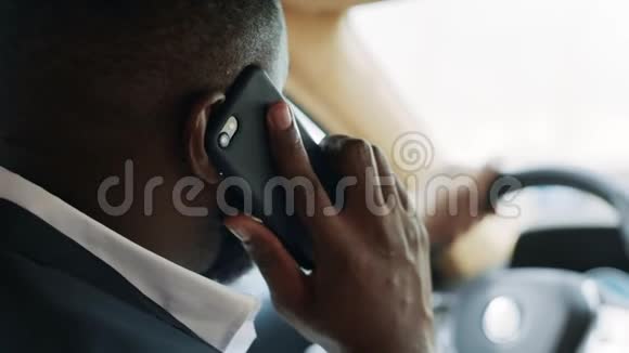 非洲男人在车上打电话的背影坐在方向盘后面的人视频的预览图