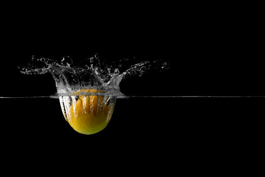 一颗掉落水中溅起水花的柠檬图片素材免费下载