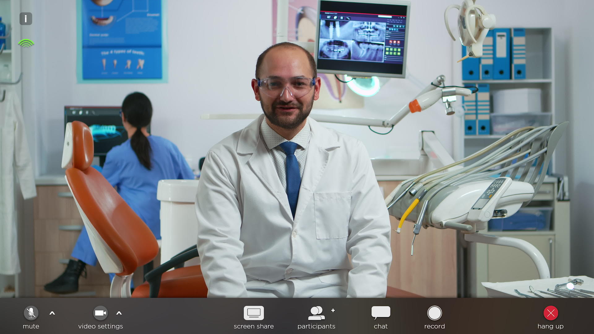 牙医在网上与患者交谈时观看相机视频的预览图