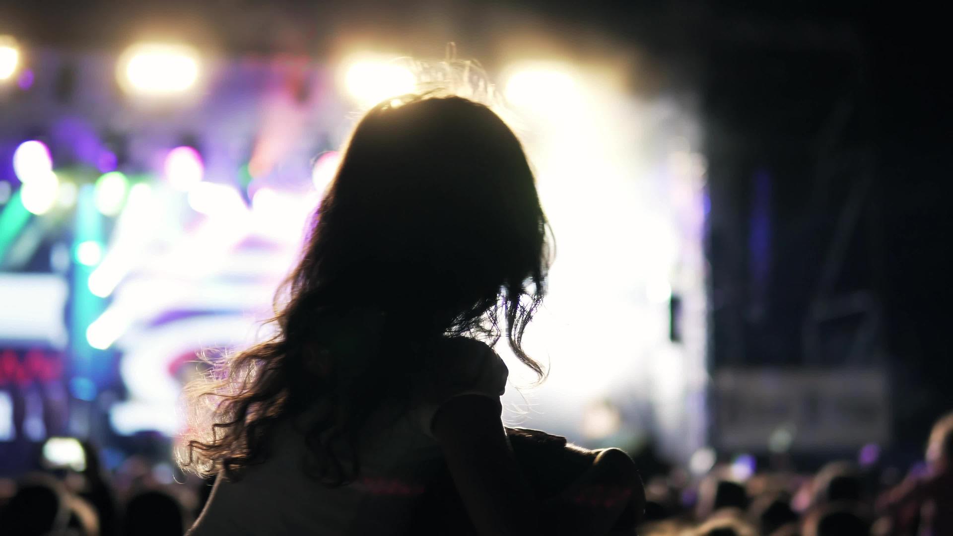 在户外音乐节的公共音乐会上一个卷发的女孩坐在肩上视频的预览图