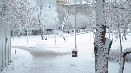在城市的雪中路边走着模糊的人视频的预览图