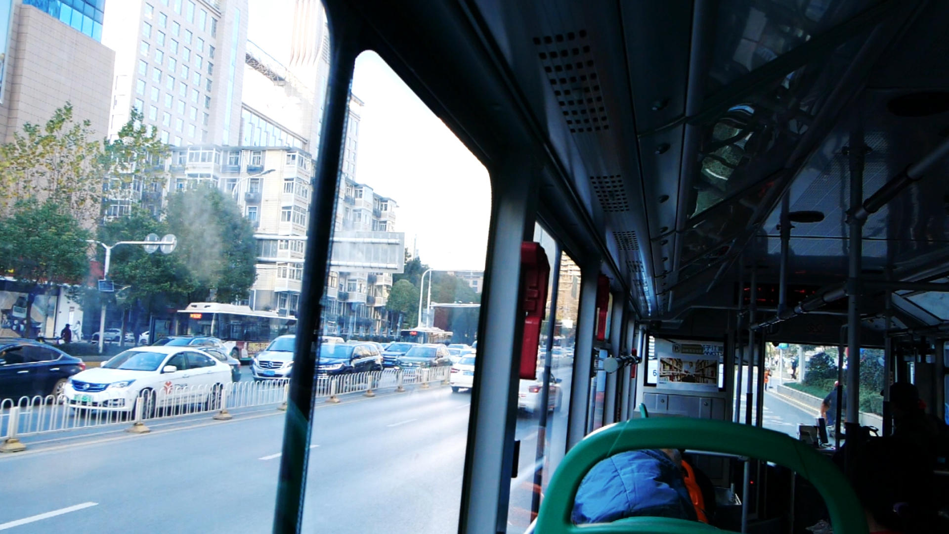 升格绿色出行行驶中的公交车车窗外的风景视频的预览图