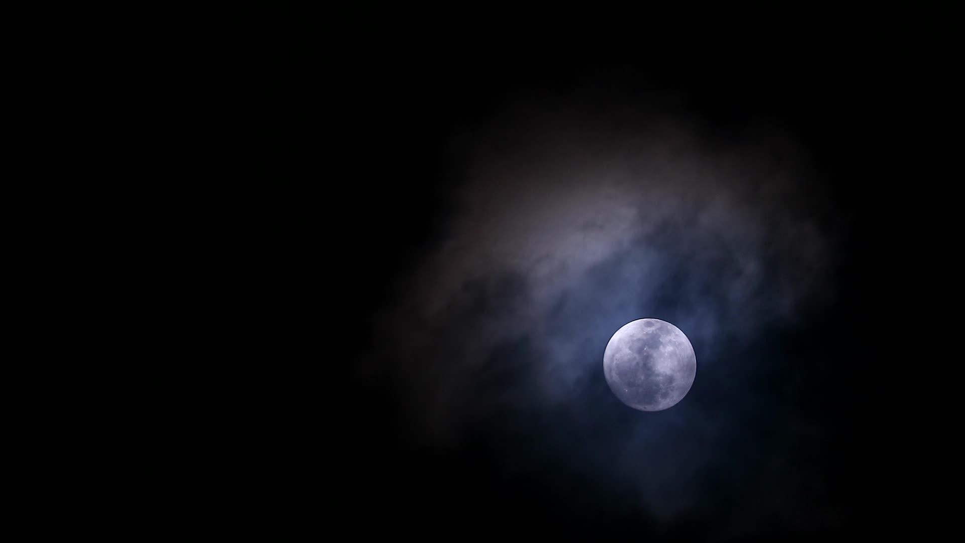 夜空中的黑月在寒冷的天空中回到柔软黑暗的云层视频的预览图