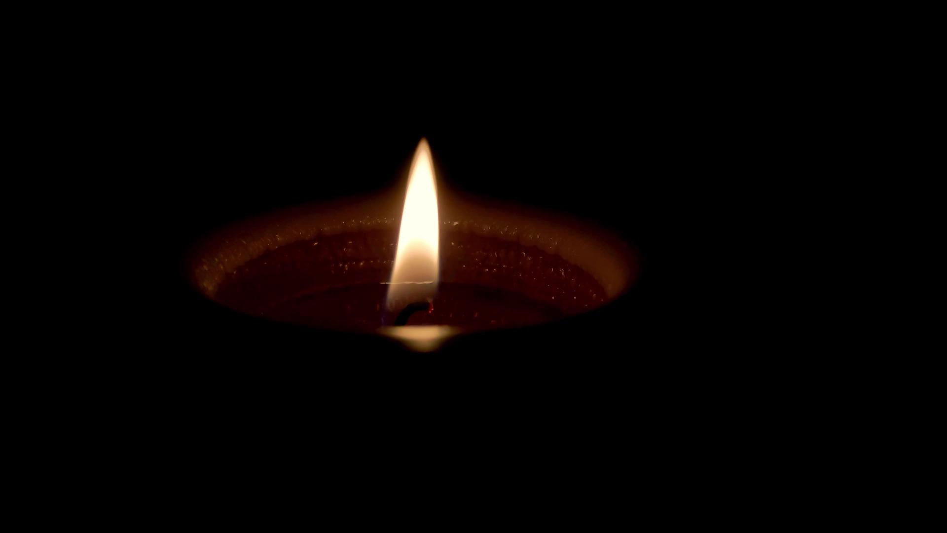 蜡烛在黑暗的背景下燃烧悲伤和死亡的概念视频的预览图