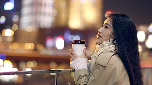 4K都市夜晚拿着咖啡的美女升格视频视频的预览图