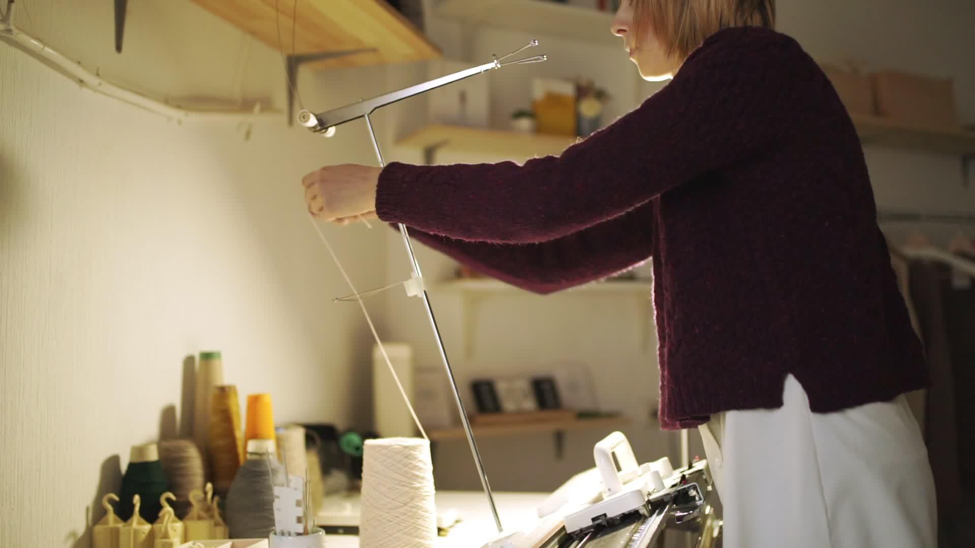 纺织工在编织机上拉线站在车间桌上视频的预览图