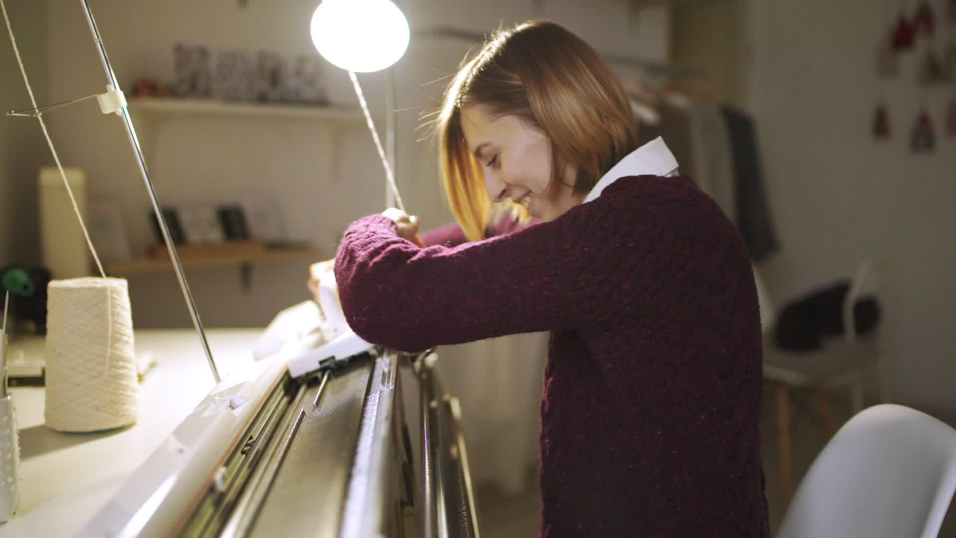 纺织车间织机上的女青年针织品视频的预览图