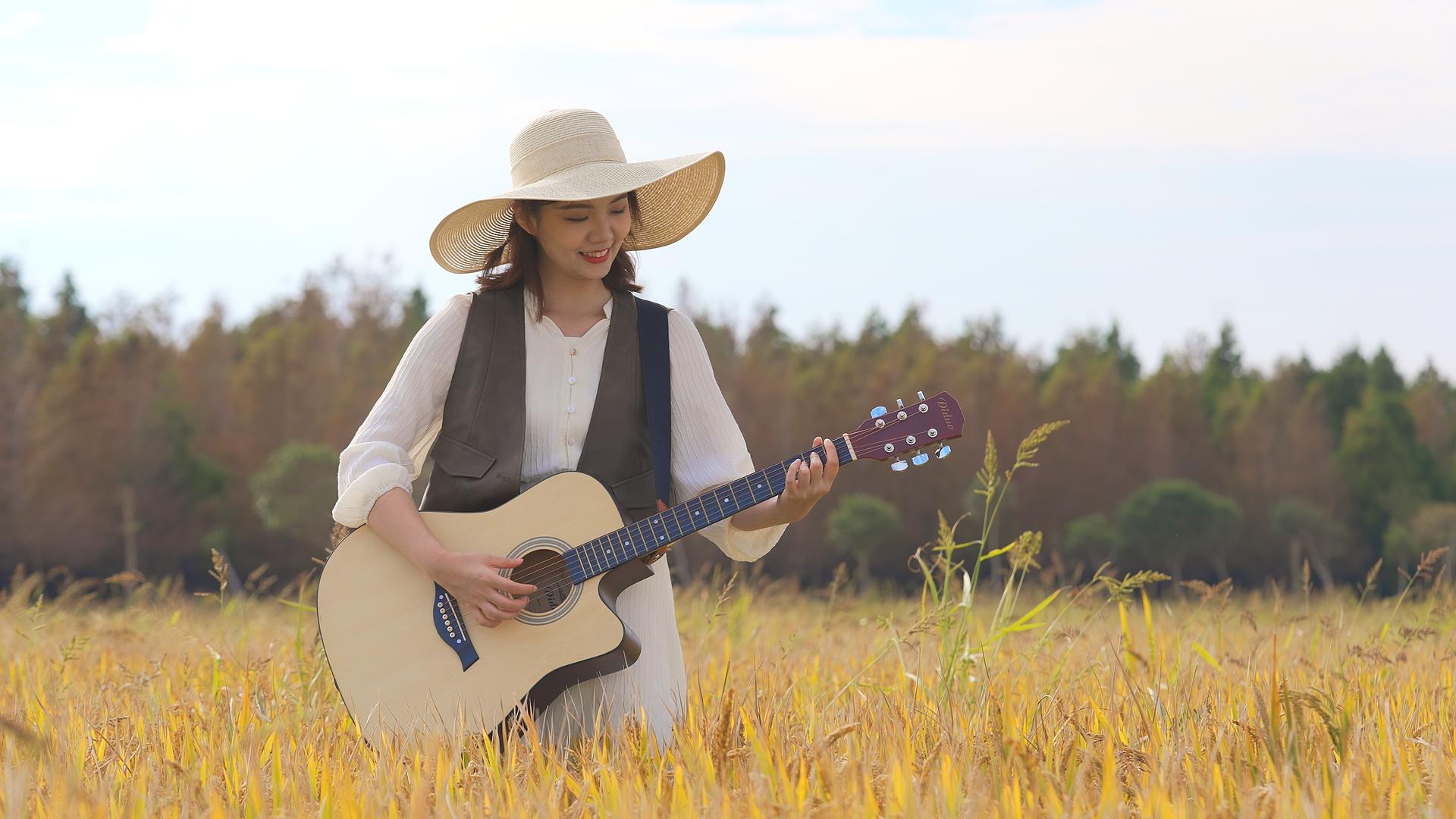 美女在稻田里快乐地弹吉他视频的预览图