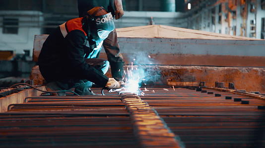 钢铁厂保护工人在口罩中焊接金属结构视频的预览图