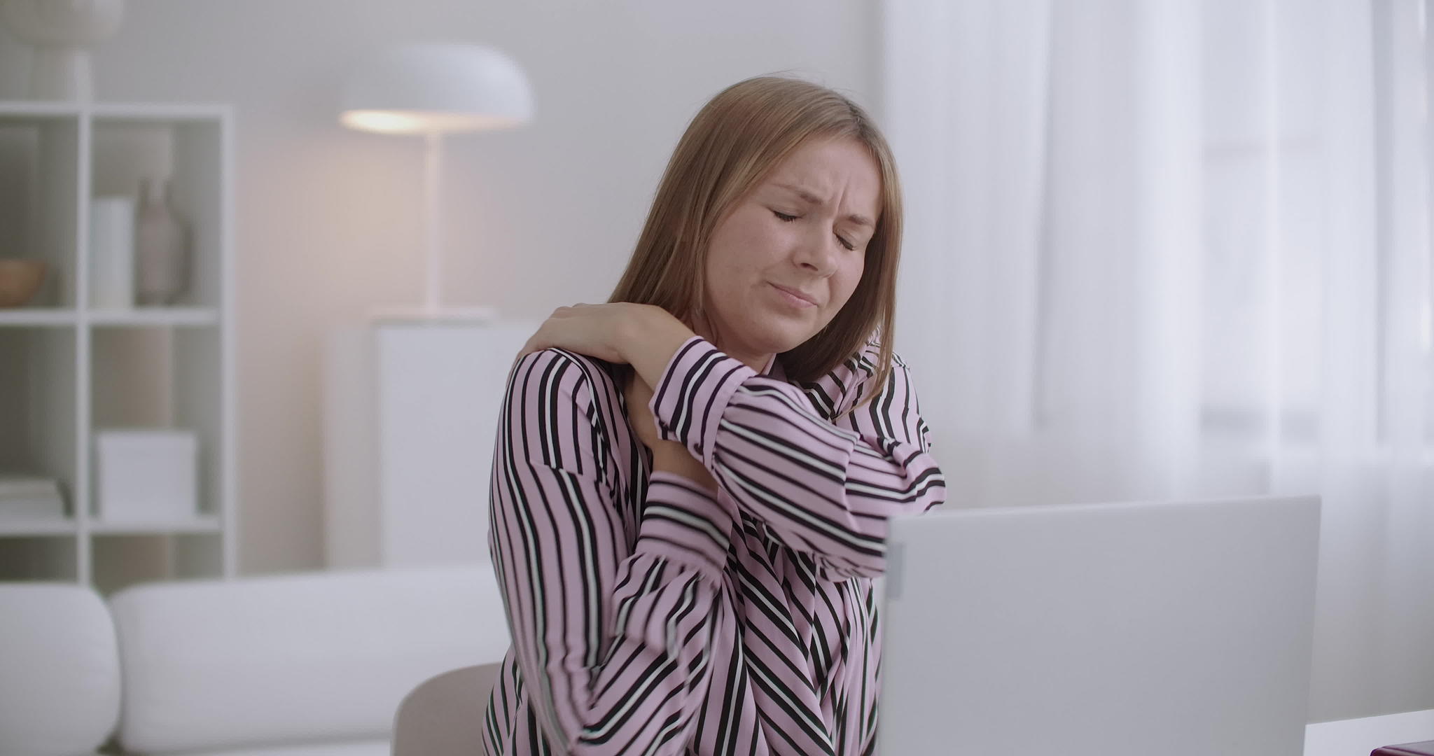 使用笔记本电脑的年轻女性感到颈部疼痛慢性宫颈骨质视频的预览图