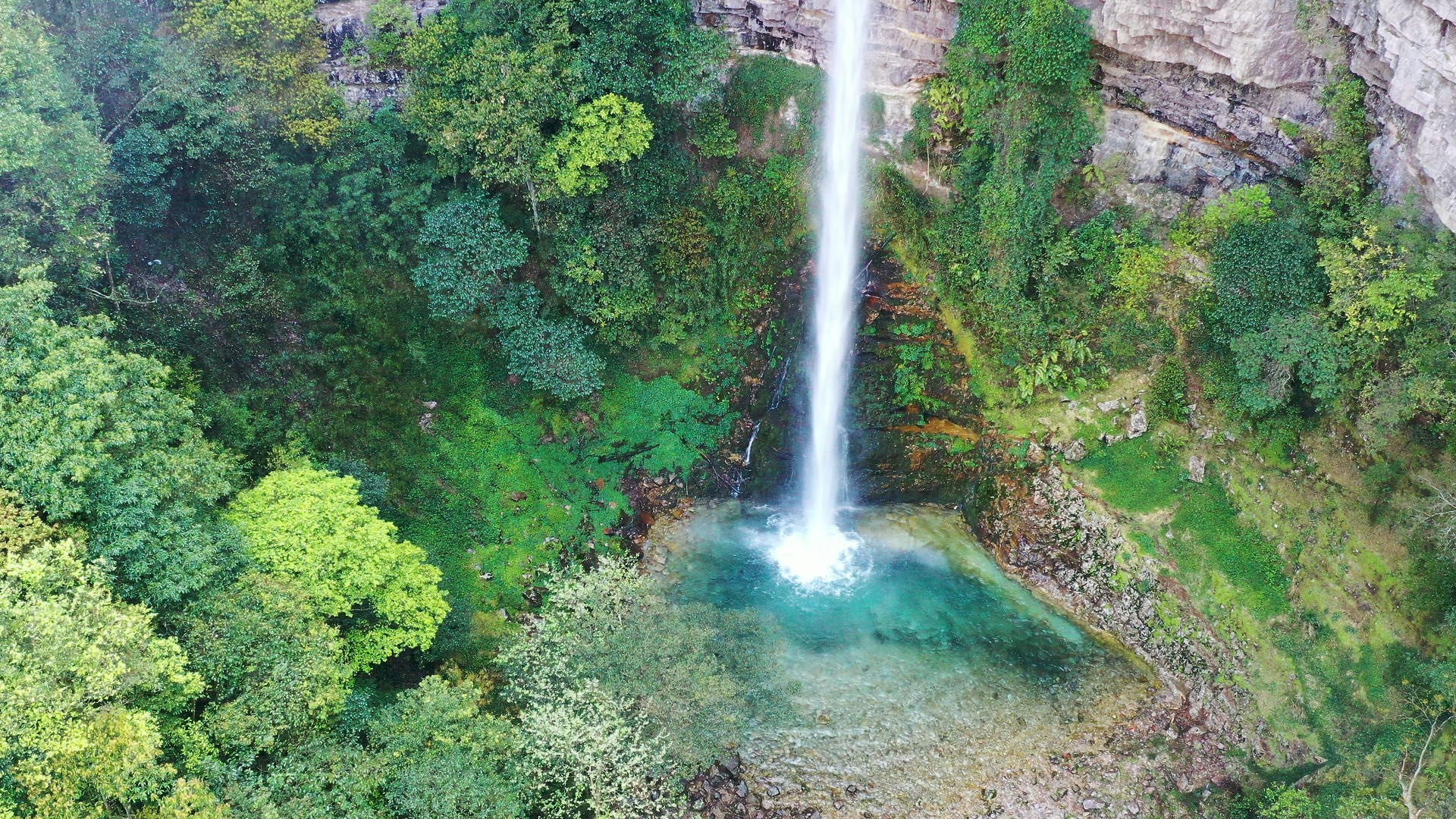 航拍深山峡谷之间清澈水流瀑布视频的预览图