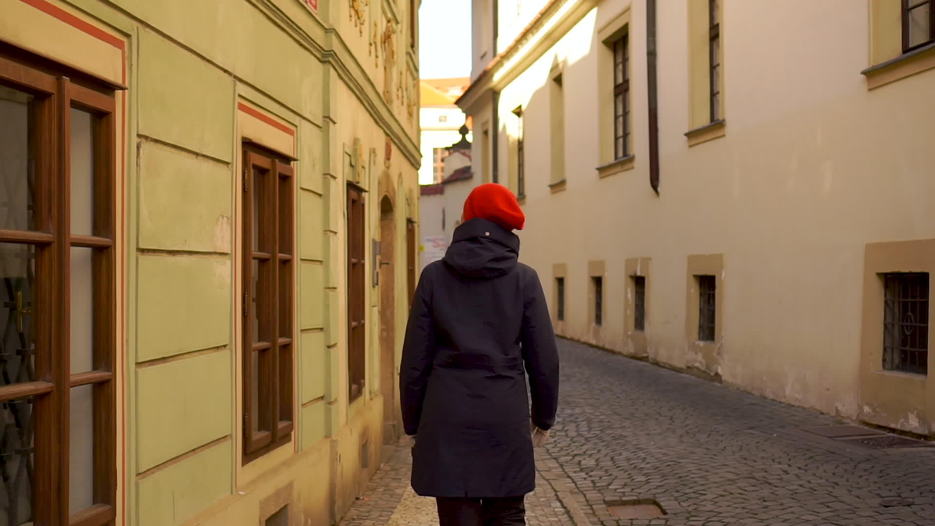 那个戴着红帽子的年轻女子走在后面的老街上·塞视频的预览图