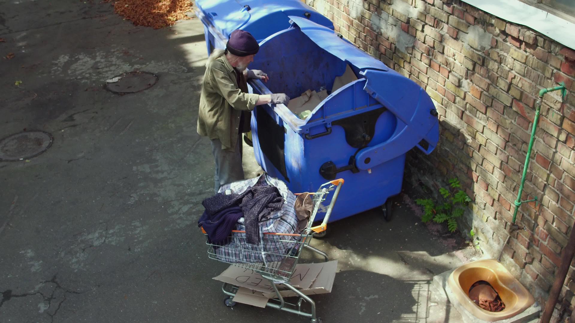 流浪汉在垃圾桶里寻找食物视频的预览图