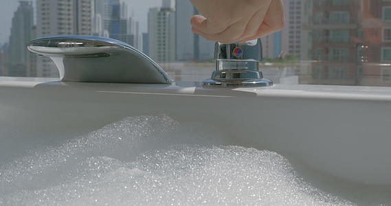 女人用泡沫把水倒进浴缸里视频的预览图