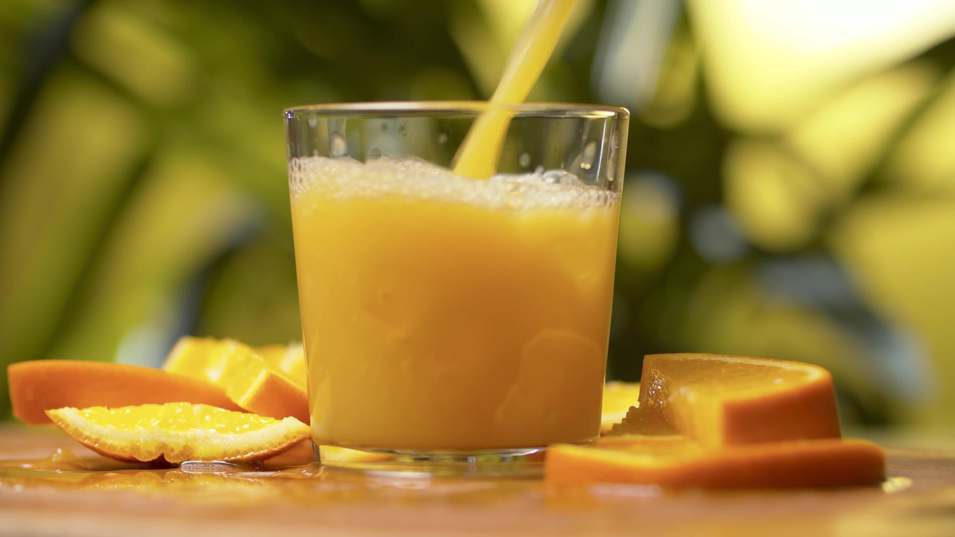 将新鲜橙汁倒入玻璃杯中视频的预览图