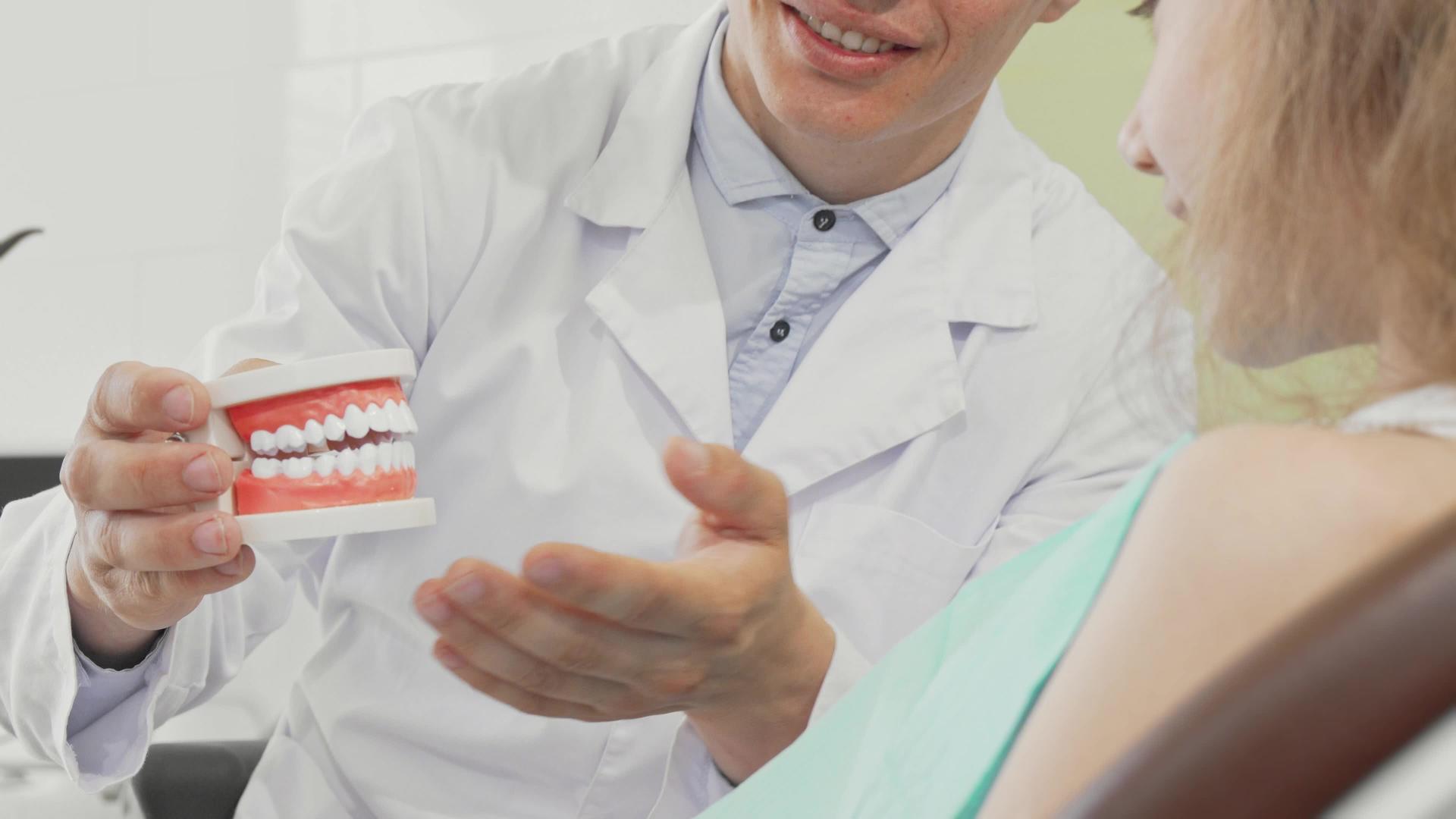 男性牙医有牙齿假牙向患者解释牙齿护理视频的预览图