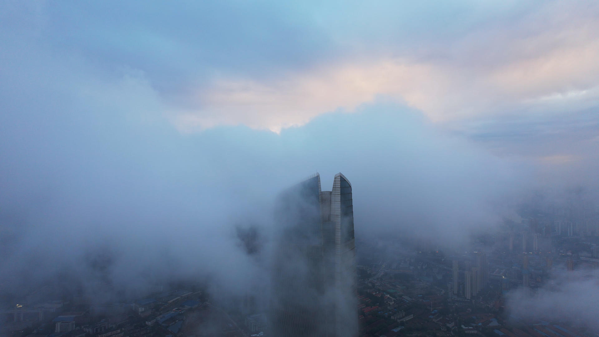 高空航拍云雾中的城市地标天际线商务中心高楼晚霞天空4k素材视频的预览图