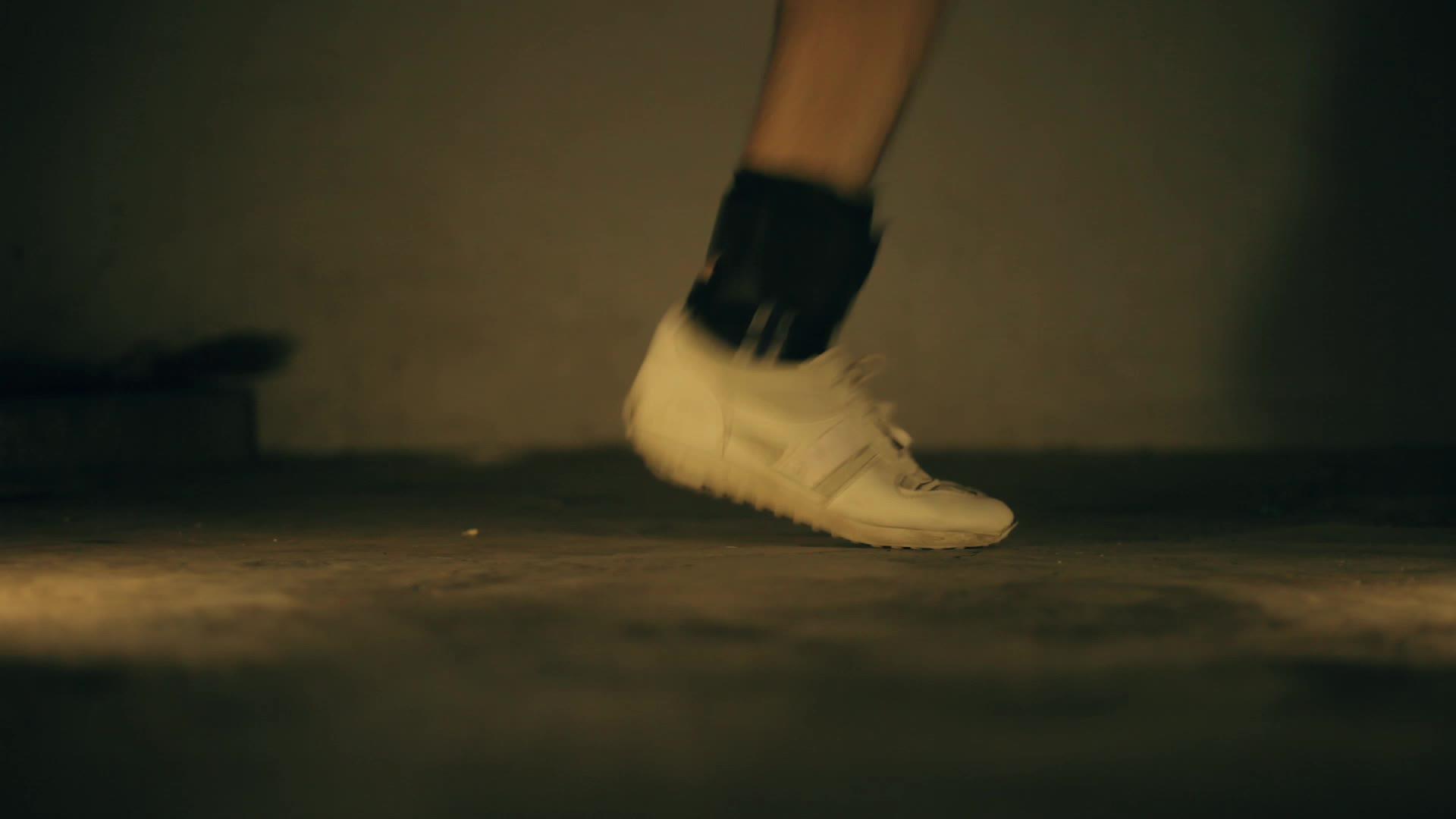 双腿穿白色运动鞋和黑色脚踝重量视频的预览图