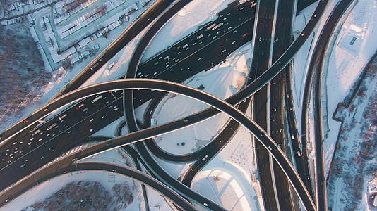 阳光明媚的冬天复杂的十字路口和汽车交通空中垂直俯视无人机视频的预览图