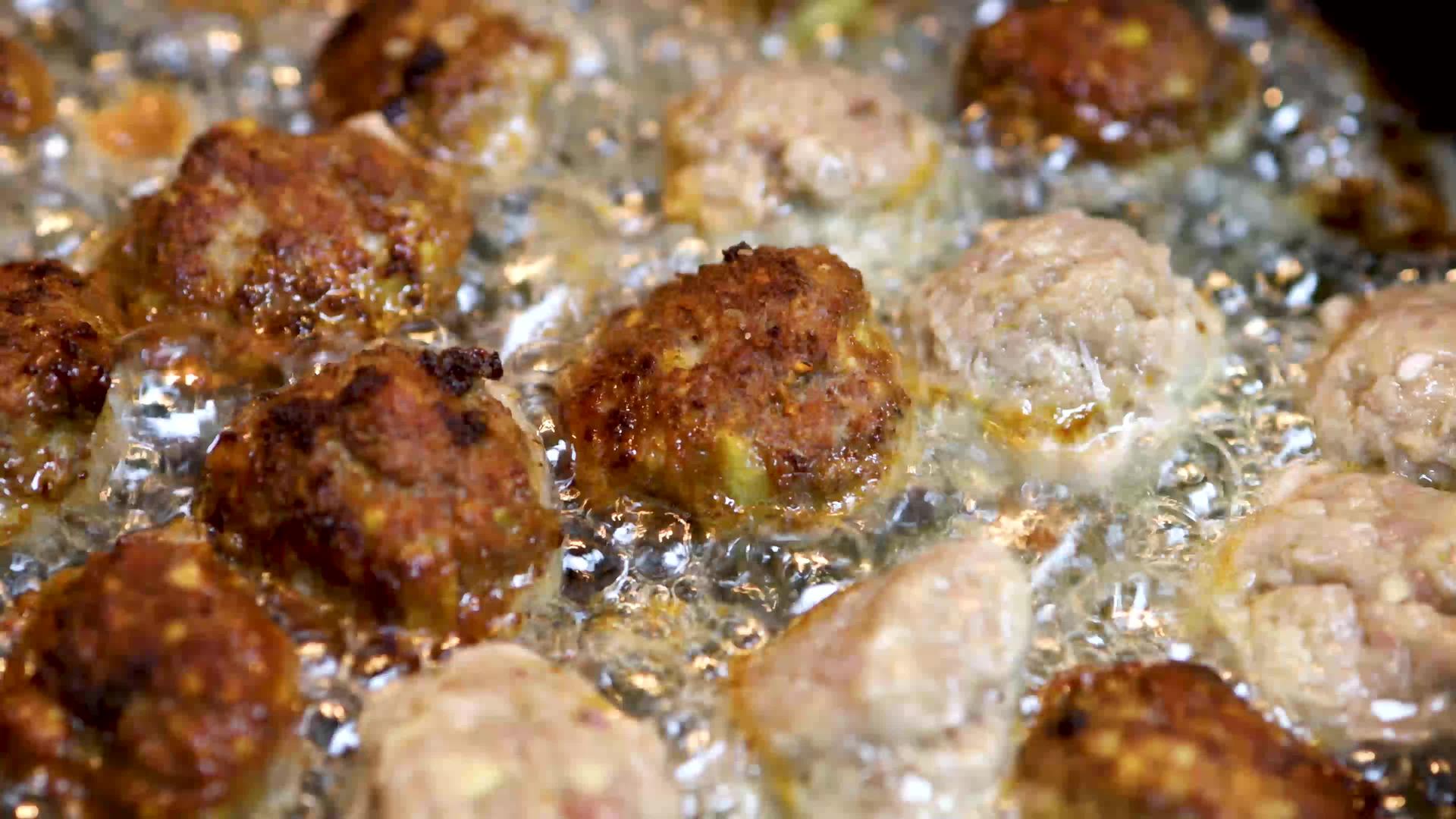 金色肉丸在沸油中煎炸不健康快速配菜的概念视频的预览图