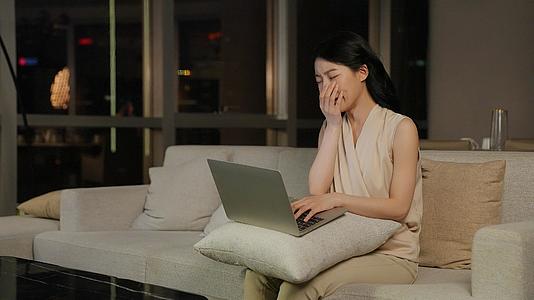 女人晚上坐在客厅工作困倦视频的预览图