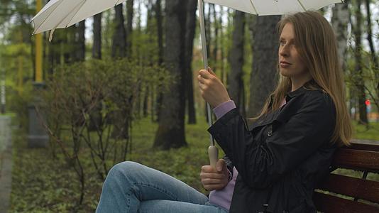 一个拿着雨伞的女人坐在凳子上视频的预览图