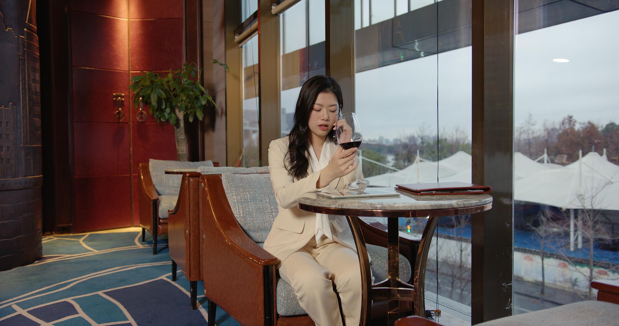 8K商务酒店女性喝红酒打电话视频的预览图