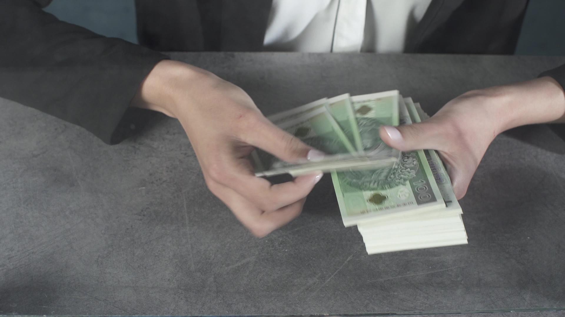 女人手里拿着一堆厚厚的钞票视频的预览图