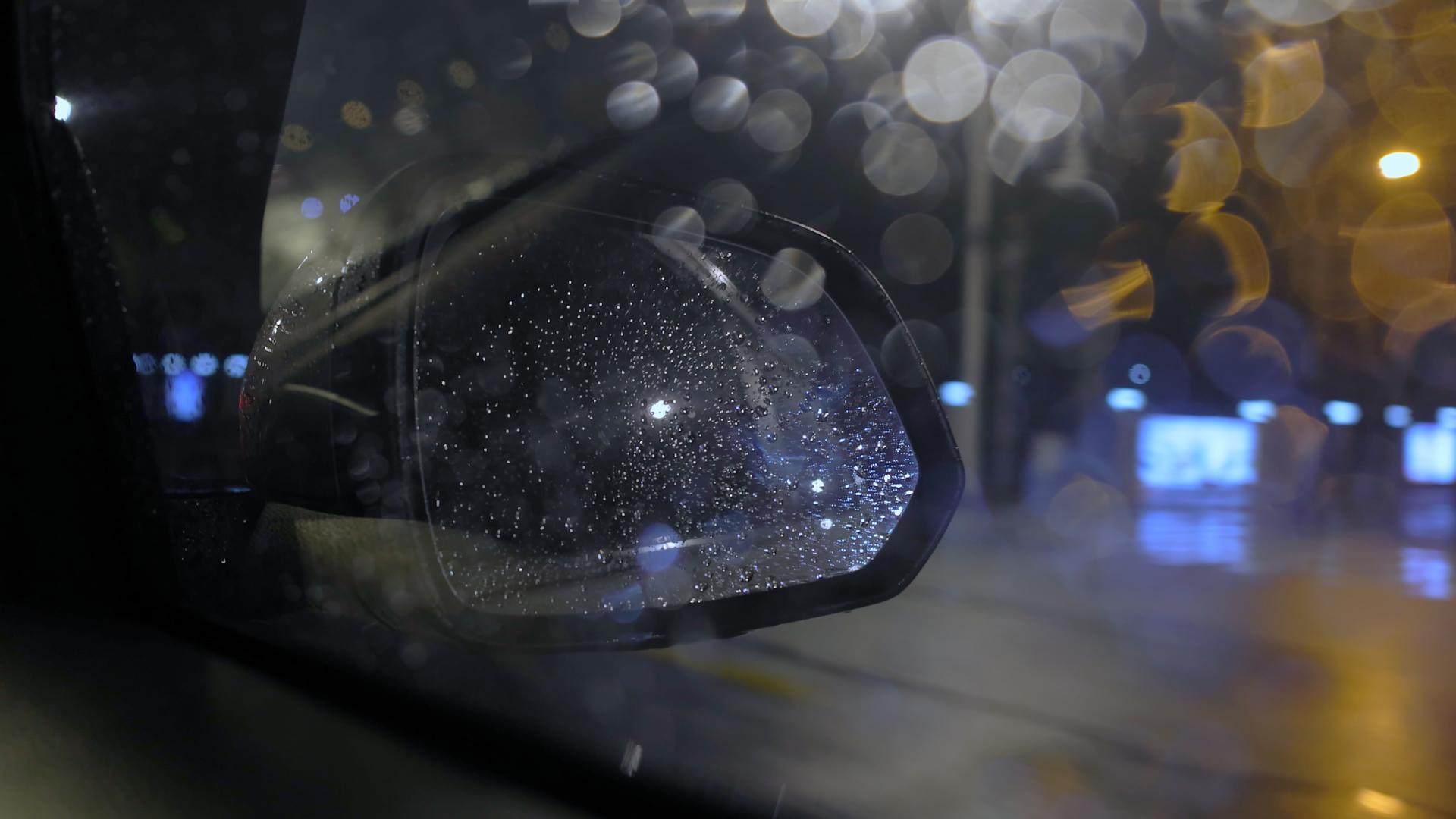 雨天晚上汽车后视镜在城市道路上行驶视频的预览图