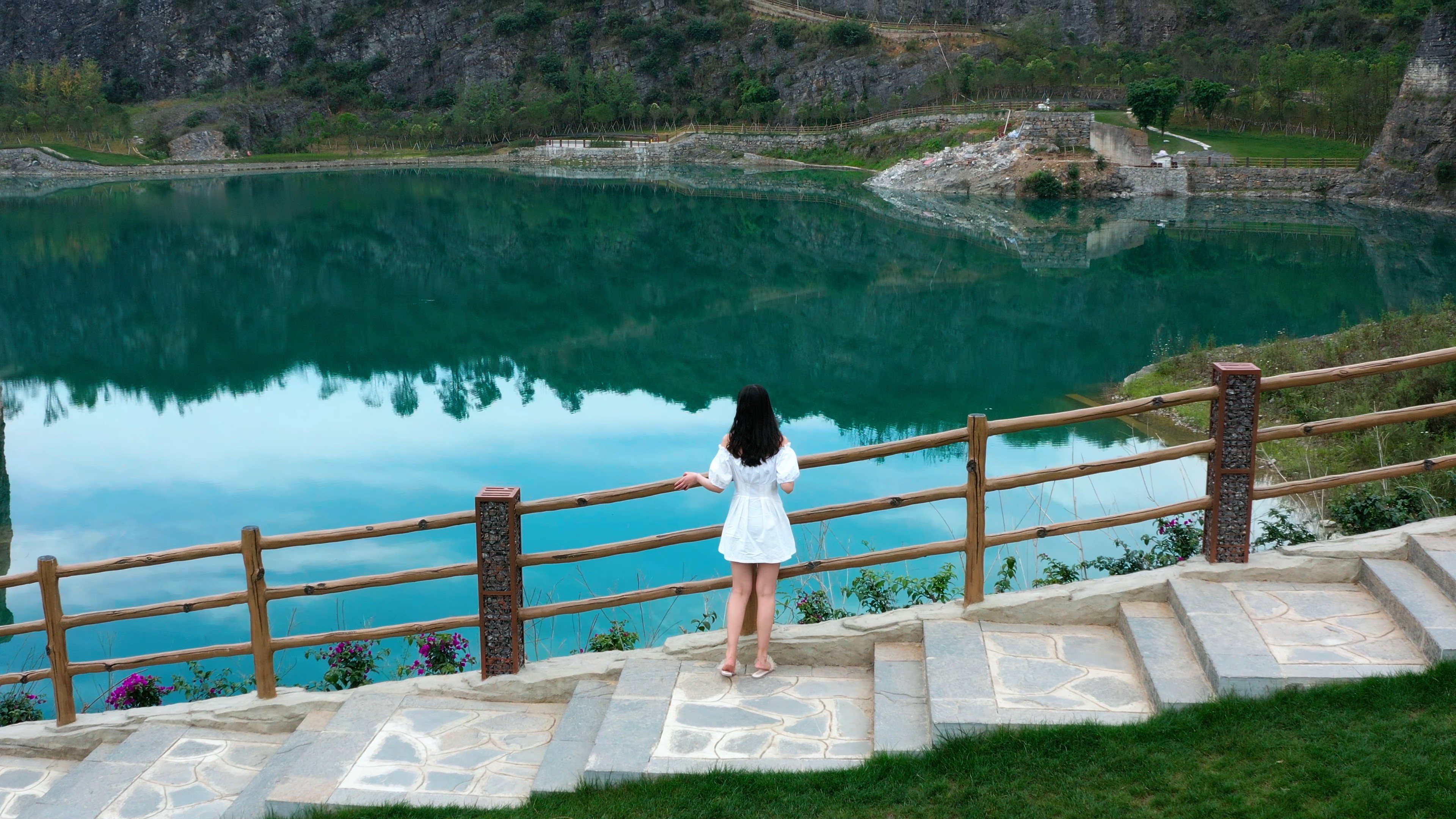 4k航拍女生走到观景台看湖水唯美风景背影视频的预览图