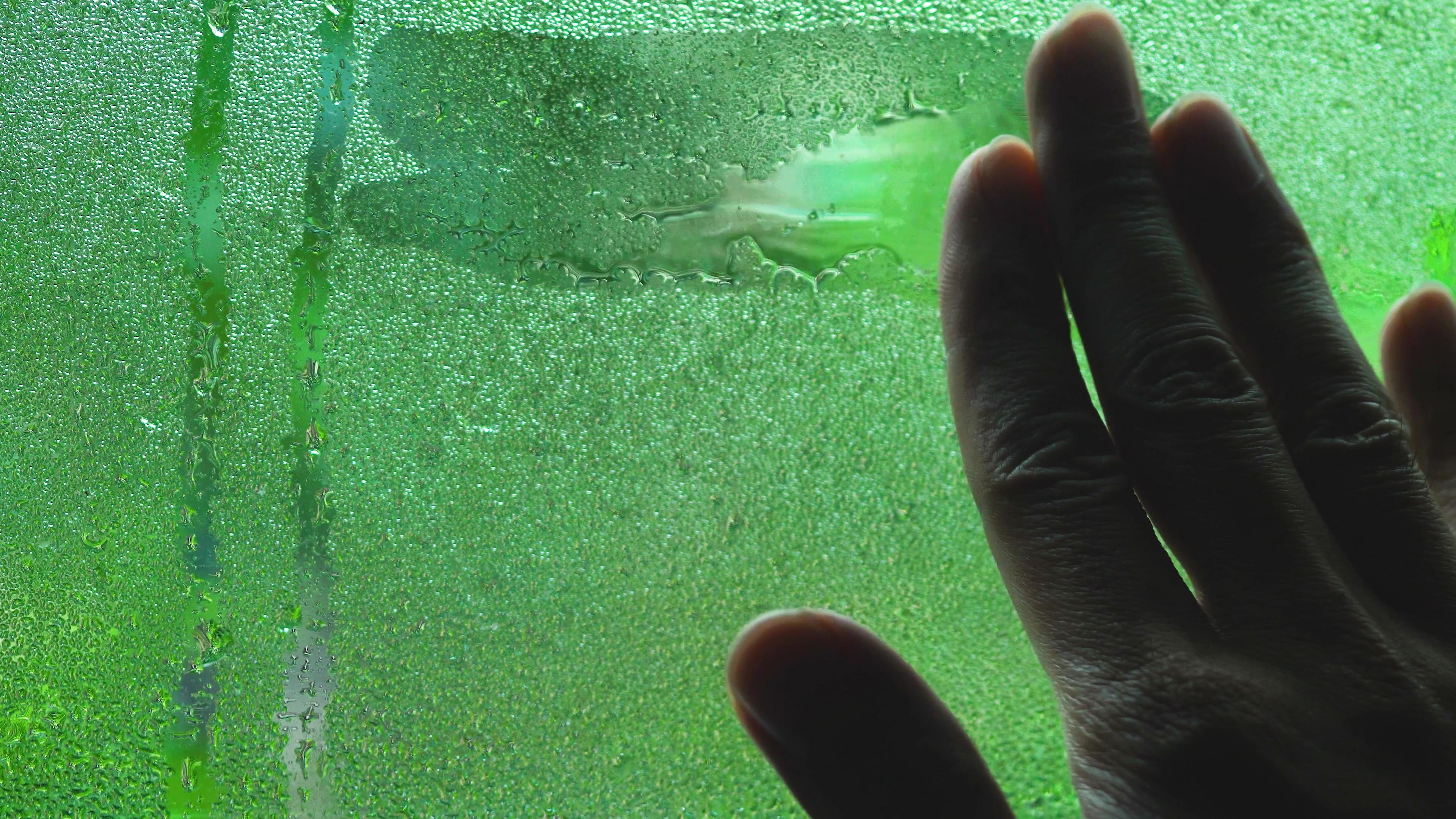 4K手抹玻璃窗上的雨水水滴擦水视频视频的预览图