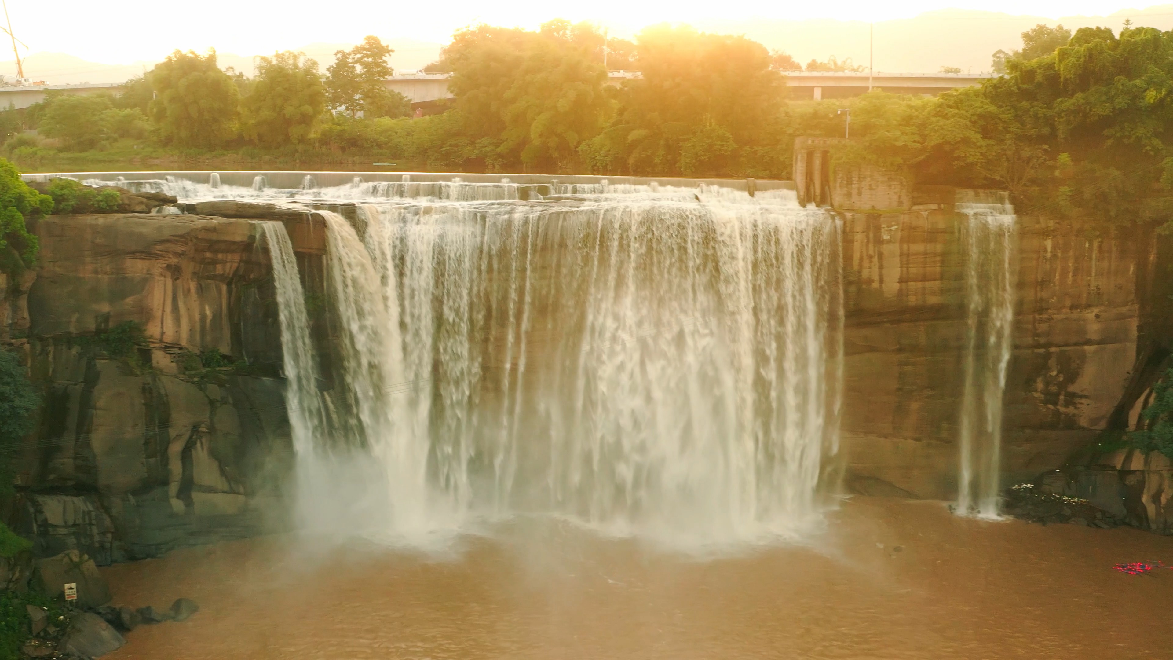 4k航拍夕阳下的瀑布水流壮丽自然风景视频的预览图