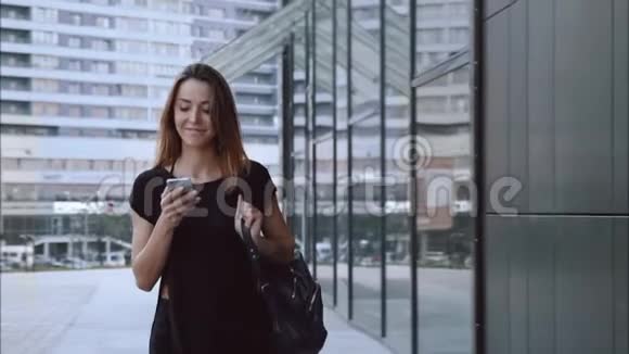 快乐和相爱的女孩带着电话走过城市视频的预览图