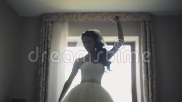 快乐的黑发新娘跳舞漂亮的女人穿着婚纱准备仪式享受这一天视频的预览图