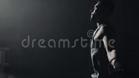 男拳击手裹着绷带跳在跳绳的暗环上慢动作剪影拳击概念视频的预览图