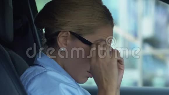 失望的女商人戴眼镜坐在车里为失败而烦恼视频的预览图