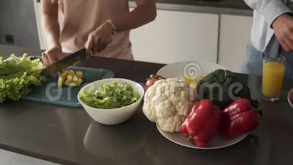 不可辨认的年轻夫妇他的手一起做饭一顿健康的饭厨房里有很多五颜六色的蔬菜视频的预览图
