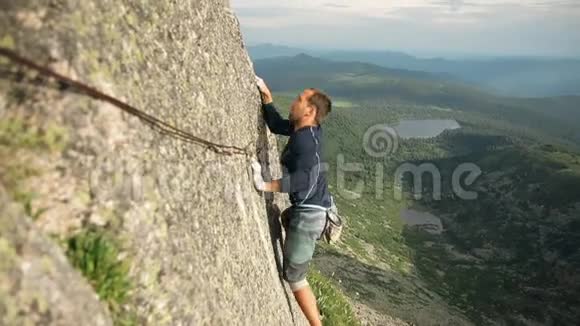 一个勇敢的年轻人独自爬上一块没有保险的高石头视频的预览图