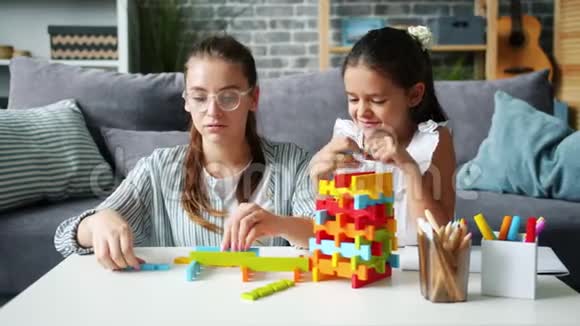 漂亮女人和快乐的女儿玩积木的慢动作视频的预览图