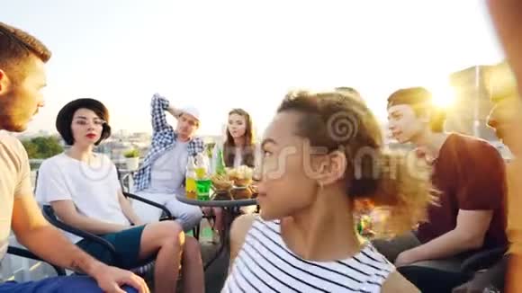 观点拍摄非裔美国女孩拿着相机和自拍与快乐的朋友在屋顶上的聚会男子视频的预览图