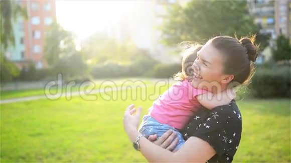 母亲和孩子在大自然中拥抱和享受户外的乐趣快乐的家庭妈妈和宝宝接吻笑视频的预览图